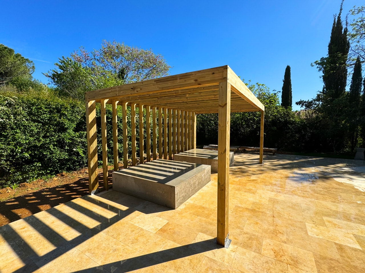 Pergola minimaliste en pin traité avec chevrons de couverture qui redescendent sur la face arrière à Roquefort les Pins, Alpes Maritimes,06